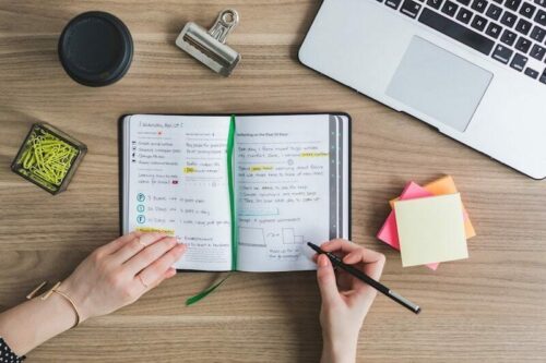 Taking notes in notebook on desk