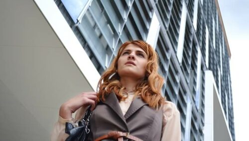 woman standing outside of tall building